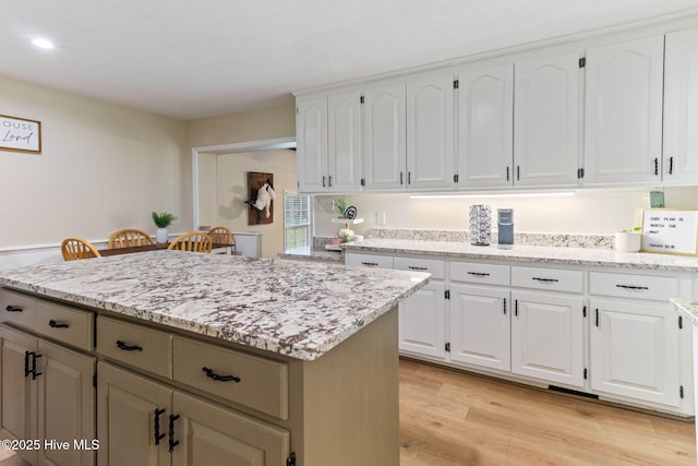 84 White Pine Rd, Lake Waccamaw, NC 28450 - kitchen featuring a center island, white cabinetry, light wood-style floors, light stone counters, and recessed lighting