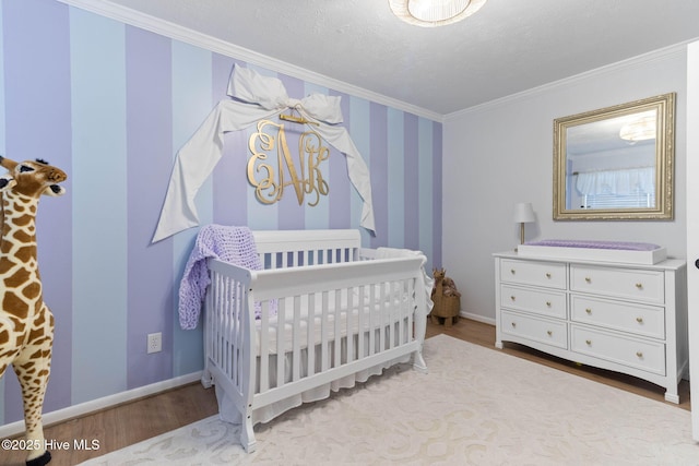 84 White Pine Rd, Lake Waccamaw, NC 28450 - bedroom featuring wood finished floors, crown molding, a nursery area, and wallpapered walls