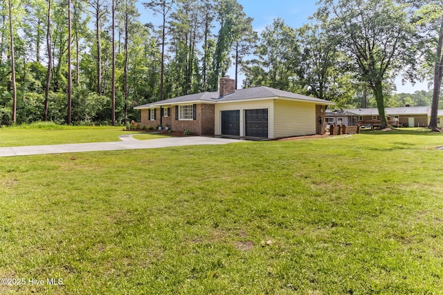84 White Pine Rd, Lake Waccamaw, NC 28450 - view of front of home featuring an attached garage, a chimney, concrete driveway, a front lawn, and brick siding