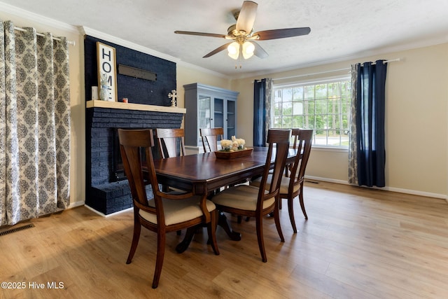 84 White Pine Rd, Lake Waccamaw, NC 28450 - dining room featuring wood finished floors, a fireplace, ornamental molding, and a ceiling fan