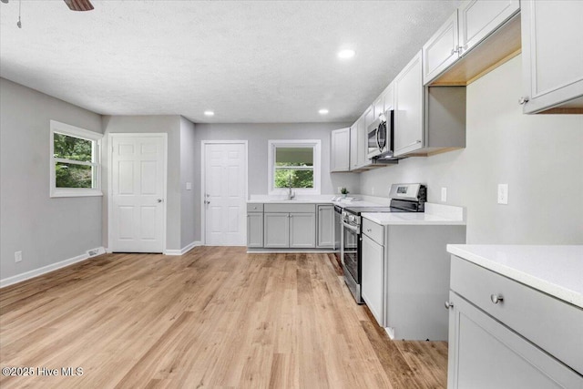 527 W College St, Warsaw, NC 28398 - kitchen featuring appliances with stainless steel finishes, light wood-style floors, light countertops, recessed lighting, and a textured ceiling