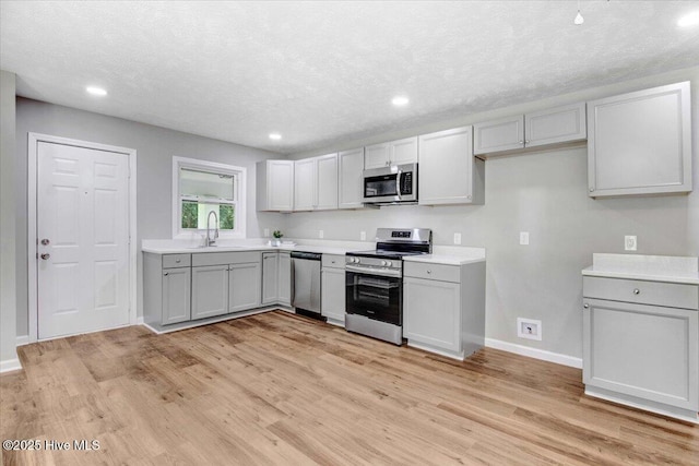 527 W College St, Warsaw, NC 28398 - kitchen with stainless steel appliances, light wood finished floors, gray cabinets, light countertops, and recessed lighting