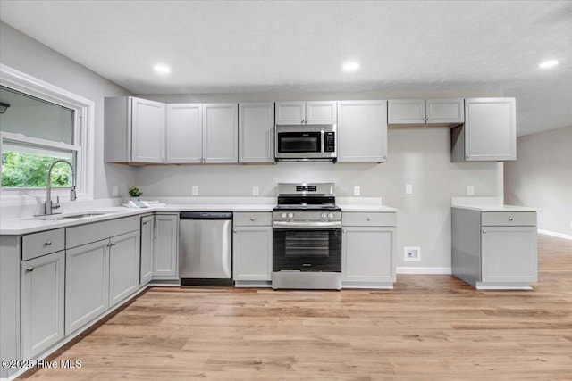 527 W College St, Warsaw, NC 28398 - kitchen featuring stainless steel appliances, gray cabinetry, light wood-style flooring, recessed lighting, and light countertops