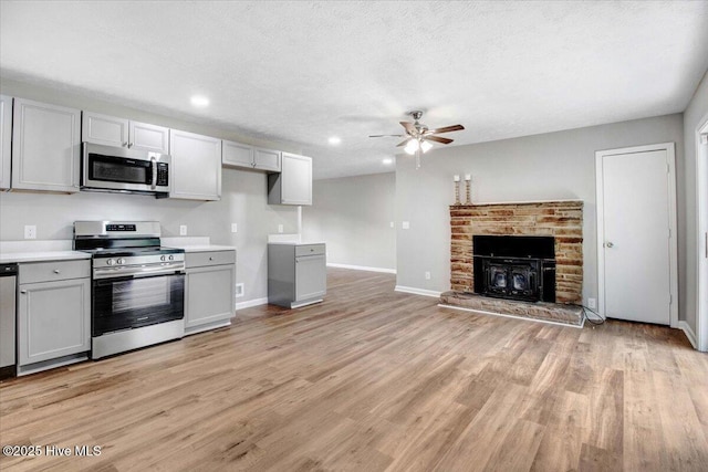 527 W College St, Warsaw, NC 28398 - kitchen with appliances with stainless steel finishes, a ceiling fan, gray cabinets, light wood-style flooring, and light countertops