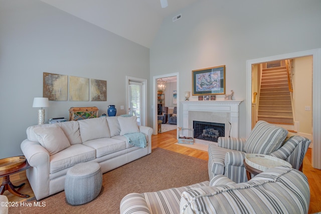 4929 Lake Renaissance Cir, Wilmington, NC 28409 - living room with high vaulted ceiling, stairs, wood finished floors, and a fireplace