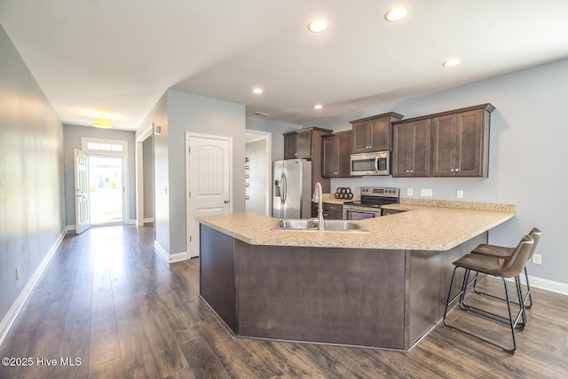 368 Lehigh Rd, Wilmington, NC 28412 - kitchen featuring stainless steel appliances, dark brown cabinetry, light countertops, dark wood-style flooring, and a peninsula