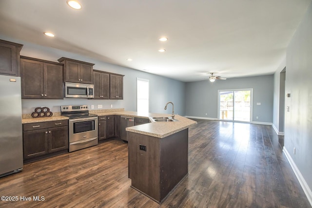 368 Lehigh Rd, Wilmington, NC 28412 - kitchen with appliances with stainless steel finishes, a peninsula, dark brown cabinetry, a ceiling fan, and dark wood-style floors