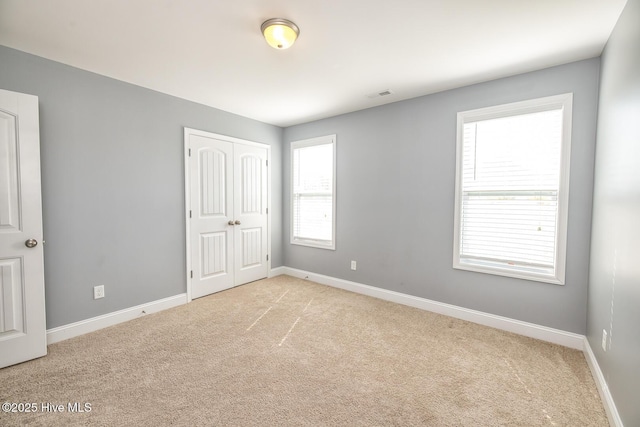 368 Lehigh Rd, Wilmington, NC 28412 - unfurnished bedroom featuring light carpet, multiple windows, and a closet
