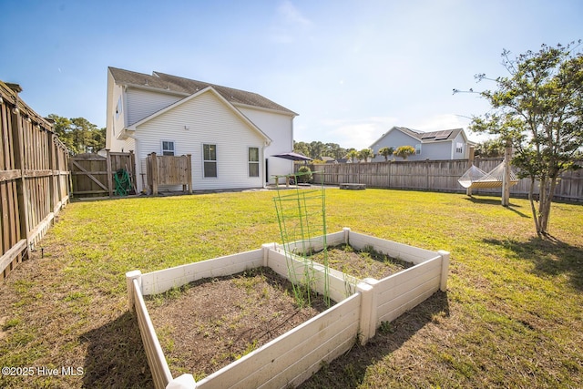 368 Lehigh Rd, Wilmington, NC 28412 - back of property featuring a garden, a fenced backyard, and a gate