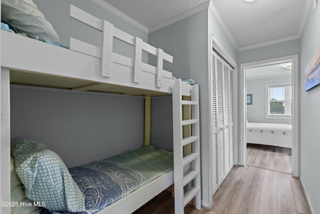 1004 Carolina Beach Ave S Unit A4, Carolina Beach, NC 28428 - bedroom featuring wood finished floors, a textured ceiling, a closet, and crown molding
