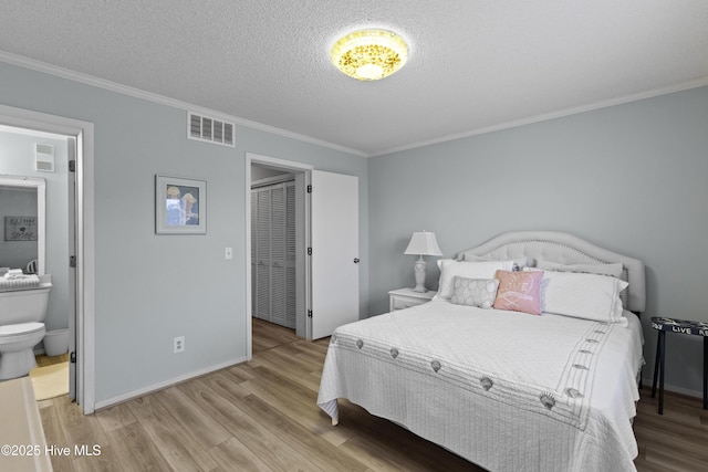 1004 Carolina Beach Ave S Unit A4, Carolina Beach, NC 28428 - bedroom featuring wood finished floors, a textured ceiling, crown molding, and ensuite bath