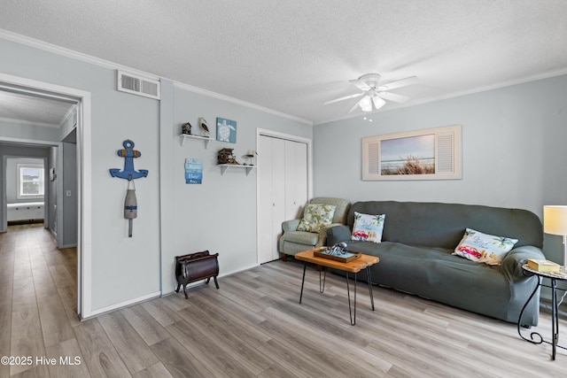 1004 Carolina Beach Ave S Unit A4, Carolina Beach, NC 28428 - living room featuring wood finished floors, a textured ceiling, crown molding, and ceiling fan