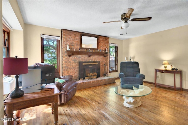 163 NW 9th St, Oak Island, NC 28465 - living area with hardwood / wood-style floors, ceiling fan, a fireplace, and a textured ceiling