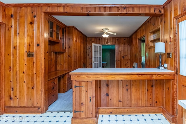 106 E New Hope Rd, Goldsboro, NC 27534 - kitchen featuring wooden walls, a ceiling fan, brown cabinets, a peninsula, and light floors