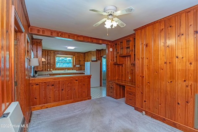 106 E New Hope Rd, Goldsboro, NC 27534 - kitchen with freestanding refrigerator, brown cabinets, a ceiling fan, and wooden walls