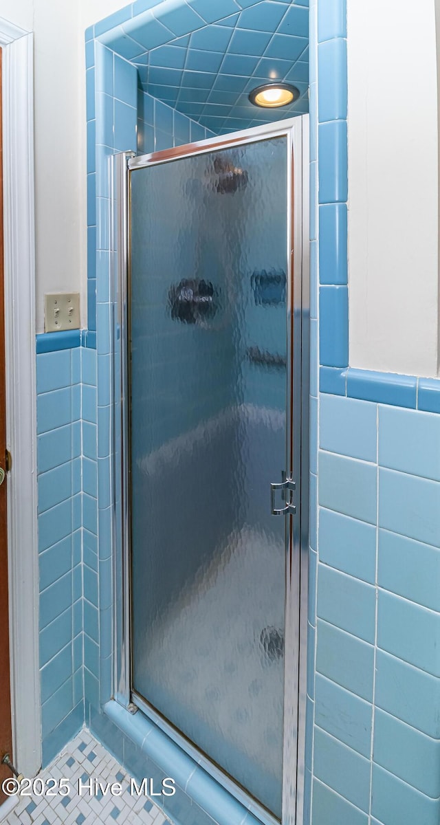 106 E New Hope Rd, Goldsboro, NC 27534 - bathroom featuring a stall shower, tile walls, and a wainscoted wall