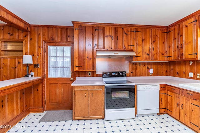 106 E New Hope Rd, Goldsboro, NC 27534 - kitchen with white dishwasher, electric range, under cabinet range hood, wooden walls, and brown cabinetry