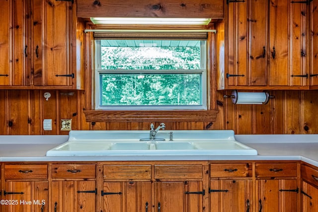 106 E New Hope Rd, Goldsboro, NC 27534 - kitchen featuring wooden walls, light countertops, and brown cabinetry