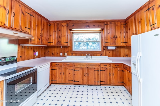 106 E New Hope Rd, Goldsboro, NC 27534 - kitchen featuring white appliances, under cabinet range hood, light flooring, brown cabinetry, and wooden walls
