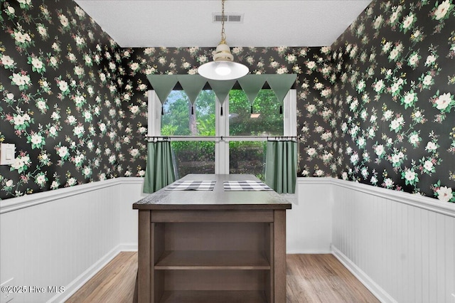 1610 Winding Way SW, Ocean Isle Beach, NC 28469 - unfurnished dining area with wallpapered walls, wood finished floors, and a wainscoted wall