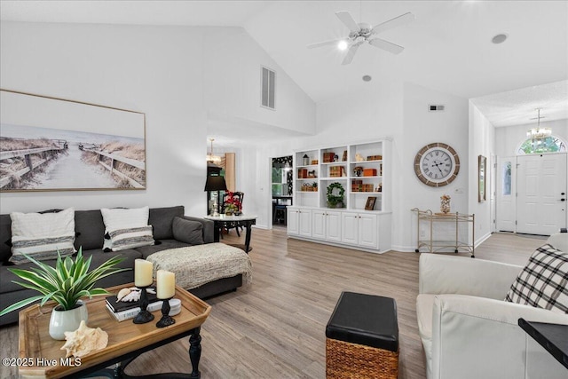 1610 Winding Way SW, Ocean Isle Beach, NC 28469 - living area featuring high vaulted ceiling, light wood finished floors, a ceiling fan, and a chandelier