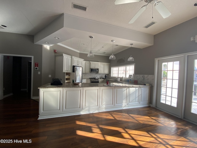 188 Edgewater Cir, Sunset Beach, NC 28468 - kitchen featuring stainless steel appliances, a peninsula, ceiling fan, light stone counters, and lofted ceiling