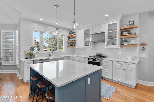 188 Edgewater Cir, Sunset Beach, NC 28468 - kitchen with open shelves, exhaust hood, white cabinets, light wood-type flooring, and recessed lighting