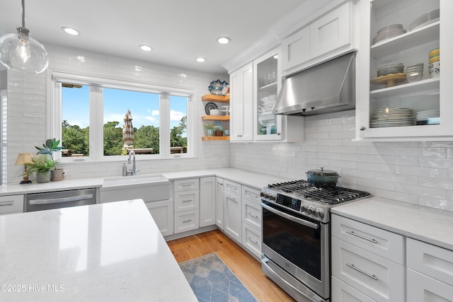 188 Edgewater Cir, Sunset Beach, NC 28468 - kitchen featuring wall chimney exhaust hood, stainless steel appliances, light countertops, white cabinetry, and recessed lighting