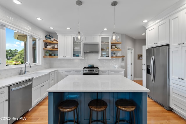188 Edgewater Cir, Sunset Beach, NC 28468 - kitchen featuring appliances with stainless steel finishes, open shelves, a breakfast bar area, light wood-style floors, and recessed lighting