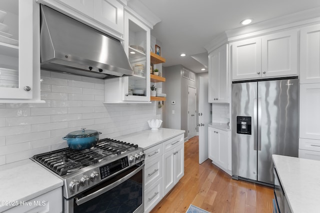 188 Edgewater Cir, Sunset Beach, NC 28468 - kitchen with stainless steel appliances, range hood, white cabinetry, light wood finished floors, and recessed lighting