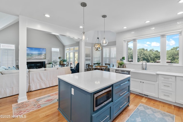 188 Edgewater Cir, Sunset Beach, NC 28468 - kitchen featuring appliances with stainless steel finishes, plenty of natural light, white cabinets, light countertops, and lofted ceiling