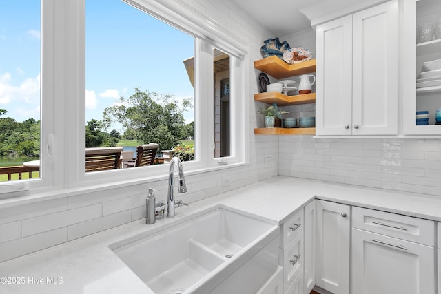 188 Edgewater Cir, Sunset Beach, NC 28468 - kitchen featuring backsplash, white cabinets, open shelves, light countertops, and glass insert cabinets