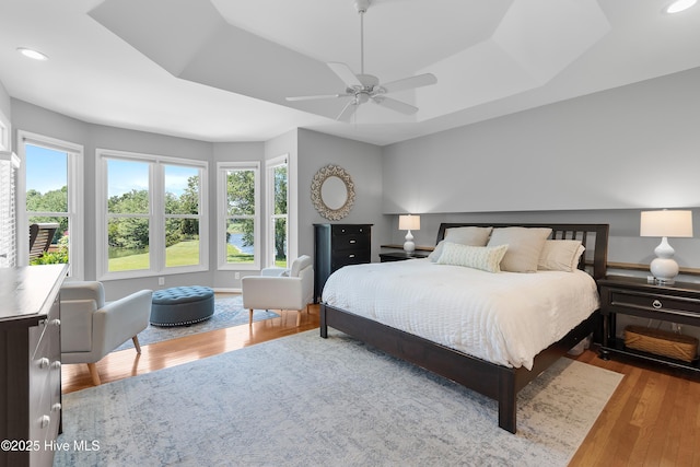 188 Edgewater Cir, Sunset Beach, NC 28468 - bedroom with wood finished floors, recessed lighting, ceiling fan, and a tray ceiling