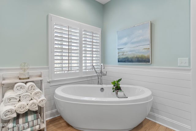 188 Edgewater Cir, Sunset Beach, NC 28468 - bathroom featuring a soaking tub, a wainscoted wall, and wood finished floors