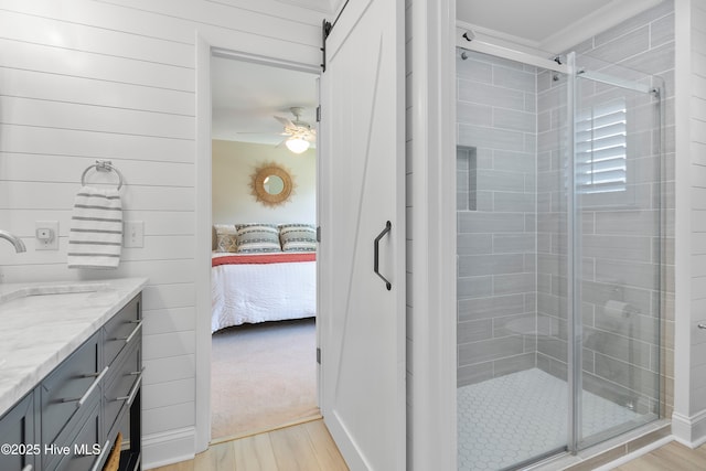 188 Edgewater Cir, Sunset Beach, NC 28468 - ensuite bathroom with wood finished floors, a shower stall, a ceiling fan, vanity, and crown molding