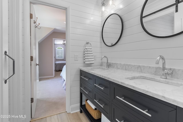 188 Edgewater Cir, Sunset Beach, NC 28468 - ensuite bathroom featuring double vanity, wood finished floors, wood walls, and vaulted ceiling
