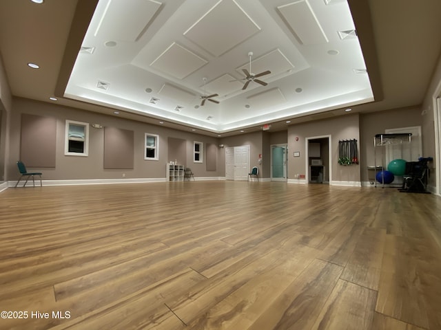 188 Edgewater Cir, Sunset Beach, NC 28468 - unfurnished living room featuring a tray ceiling, wood finished floors, and a ceiling fan