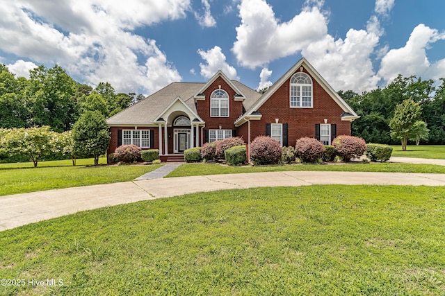 112 Highwoods Dr, Goldsboro, NC 27530 - traditional-style house with brick siding, a front yard, and curved driveway