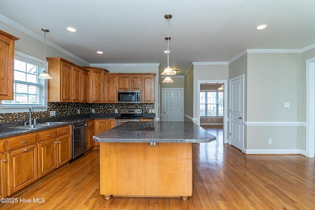 112 Highwoods Dr, Goldsboro, NC 27530 - kitchen with stainless steel appliances, light wood-style floors, a center island, decorative backsplash, and ornamental molding