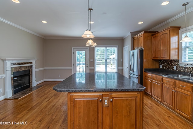 112 Highwoods Dr, Goldsboro, NC 27530 - kitchen with stainless steel fridge, light wood finished floors, brown cabinetry, a center island, and recessed lighting