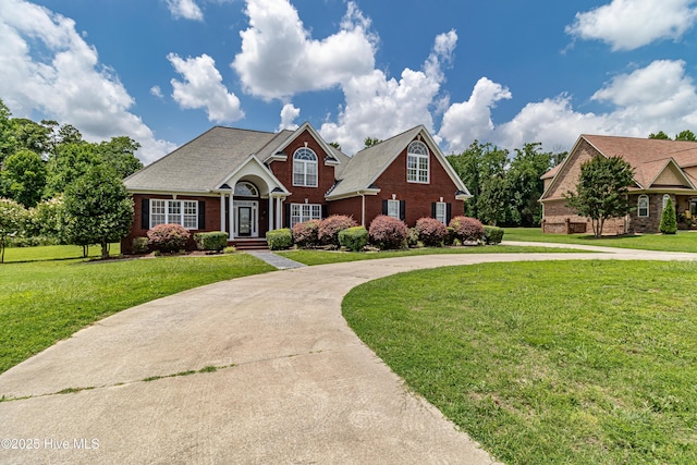 112 Highwoods Dr, Goldsboro, NC 27530 - traditional-style home with curved driveway, brick siding, and a front yard