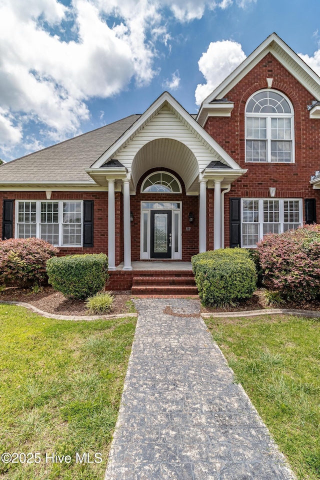 112 Highwoods Dr, Goldsboro, NC 27530 - view of front of home featuring brick siding, covered porch, and a front yard