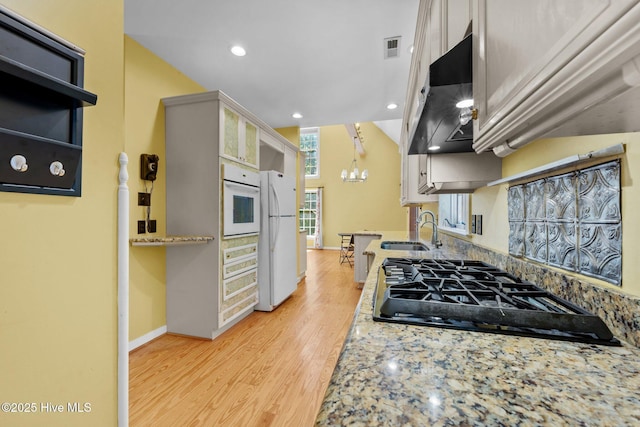 32 Windy Ct, Oriental, NC 28571 - kitchen featuring under cabinet range hood, white appliances, a chandelier, light wood finished floors, and recessed lighting