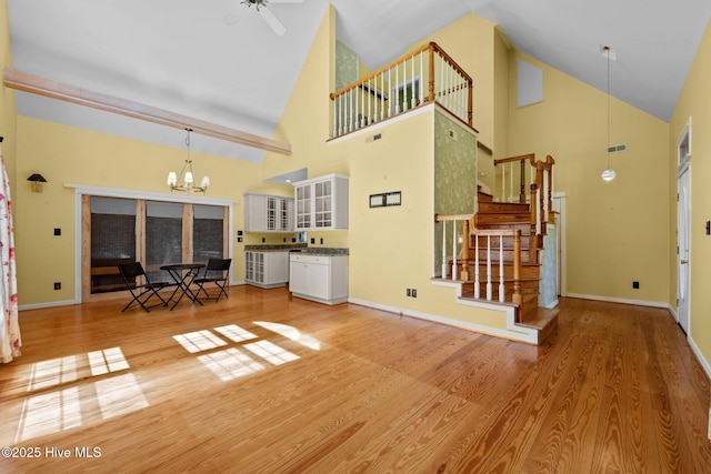 32 Windy Ct, Oriental, NC 28571 - living area with high vaulted ceiling, a chandelier, light wood-type flooring, a ceiling fan, and stairs