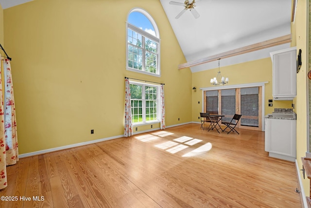 32 Windy Ct, Oriental, NC 28571 - unfurnished living room with high vaulted ceiling, a chandelier, light wood-style floors, and healthy amount of natural light