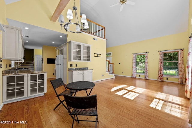 32 Windy Ct, Oriental, NC 28571 - kitchen featuring high vaulted ceiling, a chandelier, white cabinets, light wood-style floors, and a ceiling fan