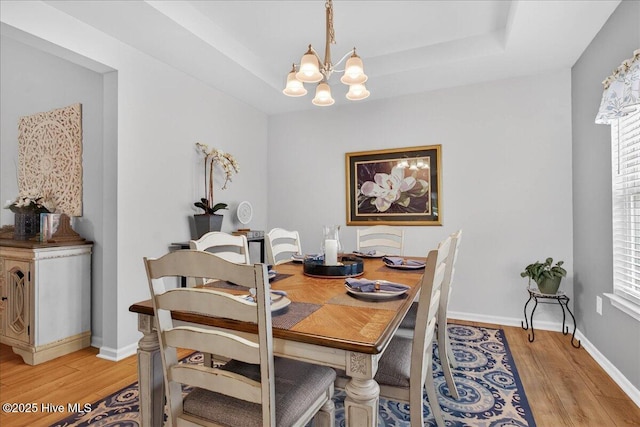 1673 White Starfish Ct, Calabash, NC 28467 - dining room with light wood finished floors, a chandelier, and a raised ceiling