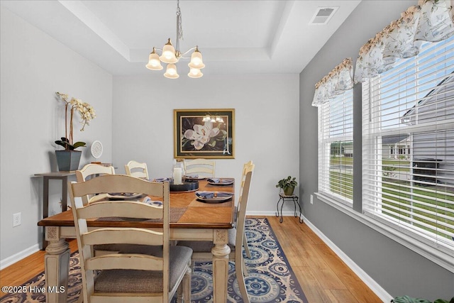 1673 White Starfish Ct, Calabash, NC 28467 - dining room featuring a chandelier, a tray ceiling, and light wood-type flooring