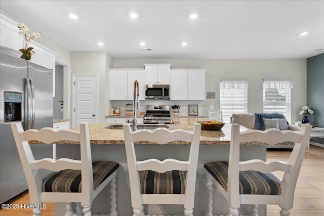 1673 White Starfish Ct, Calabash, NC 28467 - kitchen with stainless steel appliances, tasteful backsplash, a kitchen breakfast bar, light stone counters, and recessed lighting