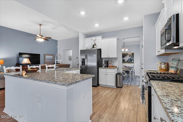 1673 White Starfish Ct, Calabash, NC 28467 - kitchen with appliances with stainless steel finishes, light wood-style floors, open floor plan, ceiling fan, and white cabinets